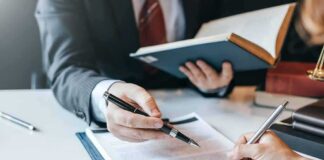 Hands signing a legal document at a desk