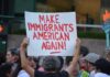 ICE Shooting Ignites City Standoff Teddy Williams at a protest holding a sign reading 'Make Immigrants American Again'