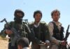 Three armed men standing outdoors