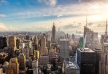 Governor BEGS Millionaires to Return – Entire State BANKRUPT! Aerial view of New York City skyline featuring the Empire State Building at sunset