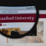 Close-up view of Stanford Universitys website through a magnifying glass