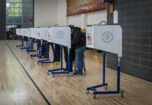 Trump Releases Cybersecurity Plan on Safeguarding the Midterms Voters at polling booths in a gymnasium
