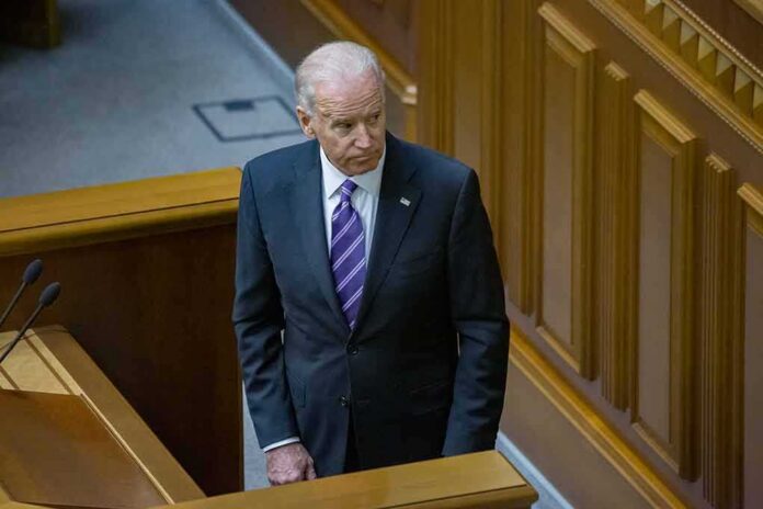 Joe Biden standing in a wood-paneled chamber in a dark suit