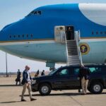 Air Force One MEdia Shake-Up Sparks Fury Security detail near blue and white aircraft with staircase and SUV