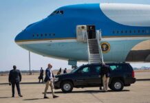 Air Force One MEdia Shake-Up Sparks Fury Security detail near blue and white aircraft with staircase and SUV