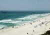 Sandy beach with turquoise waves and a long pier
