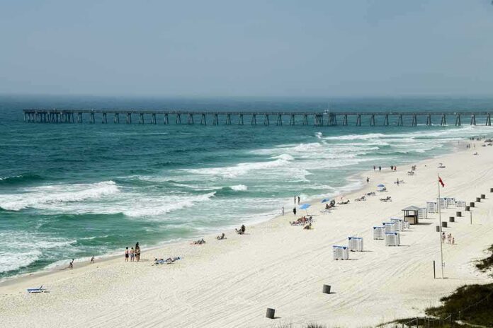 Sandy beach with turquoise waves and a long pier