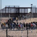 Africans Who Stormed Spanish Border Are Pooping Everywhere Crowd of people lining up near a border fence with barbed wire