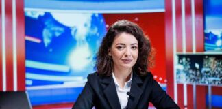 News anchor seated at a broadcast desk
