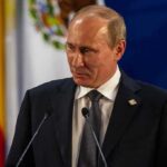 Putin’s Power Grab: Rules Get Rewritten Vladimir Putin at a podium during a formal event
