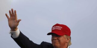 Donald Trump waving in a red cap