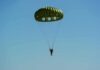 Skydiver’s Unconscious Freefall From 10,000 Feet – And Lived! Parachutist descending under a green round canopy