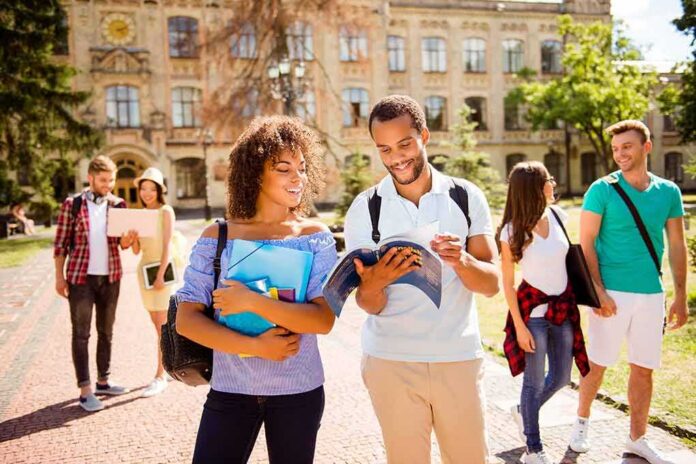 College students walking on campus with books and backpacks