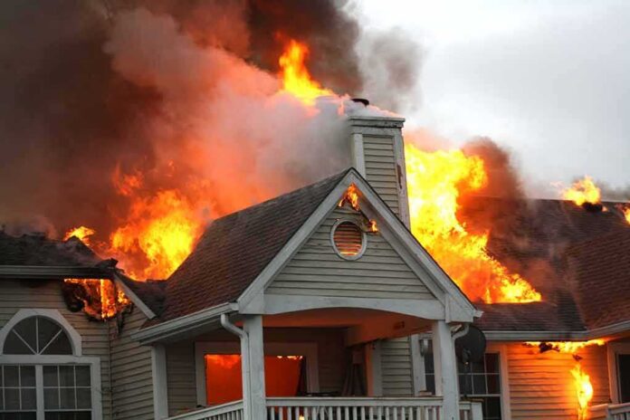 shutterstock_738714538 House engulfed in flames with heavy smoke from the roof