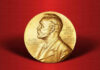 Trump Torches Nobel: ‘Stain On Norway’ Gold Nobel Prize medal on red background.