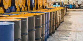 Rows of industrial metal barrels with yellow lids