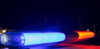 Gunfire Erupts Outside Royal Palace Police car light bar flashing blue and red at night