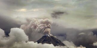 Volcano Awakens: Erupts 10 Times in One Day! Volcano erupting with ash plume above cloud layer