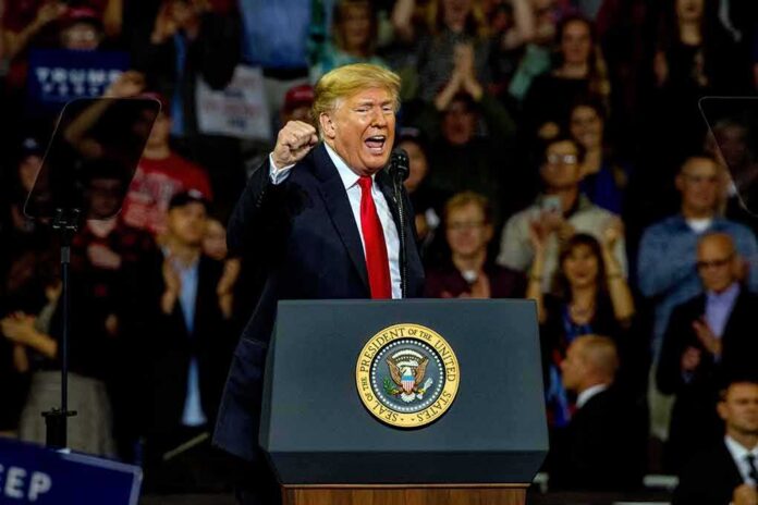 shutterstock_1204270459 Donald Trump speaking at a rally behind a presidential podium