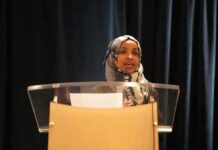 Fox News Reveals ‘Ilhan Omar’ Was Never Her Name! Woman in hijab speaking at a podium