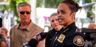 Police chief speaking to reporters with microphones