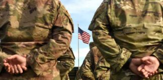 Woke Governors Execution Warning is BANANAS! Soldiers in camouflage stand with hands behind backs facing a U.S. flag