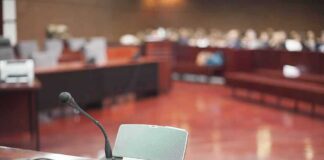 Saudi Mole Accused of BUGGING AI Headquarters Conference microphone on a desk in a courtroom