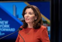 Count How Many Times Candidate Said Trump During Debate Kathy Hochul speaking at a podium with microphones