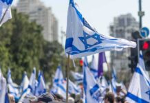 Netanyahu Posts Disturbing Atomic Bomb Pic Over City Israeli flags waved at a street demonstration