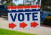 Election sign with the word VOTE and red arrows