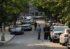 Homecoming Gunfire Suspect Walks Free Police officers secure a residential street with patrol cars and yellow tape