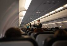 Flight attendant demonstrates safety procedures in airplane cabin