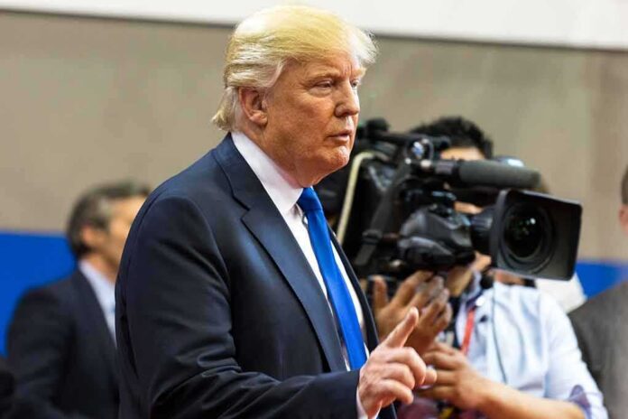Donald Trump speaking with media cameras in the background